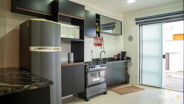y cocina con refrigerador y fogones. horno superior en Sobrado Praia do Mariscal com 3 dormitórios, en Bombinhas