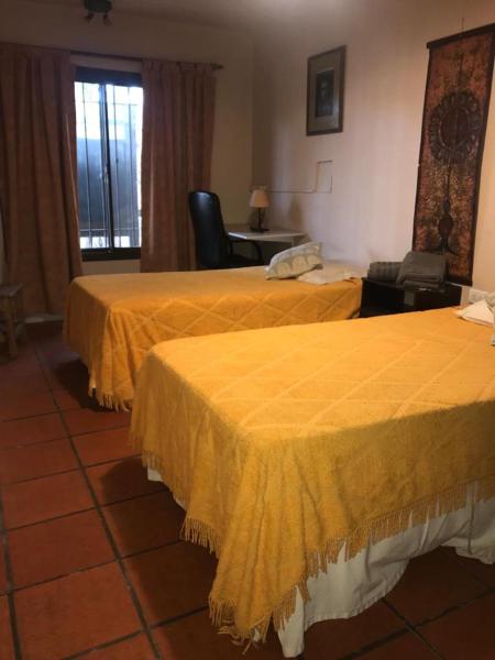 Habitación de hotel con 2 camas con sábanas amarillas en Casa amplia en Godoy Cruz en Mendoza