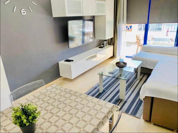 sala de estar con mesa y TV en Luxurious aparment benalmadena, en Málaga