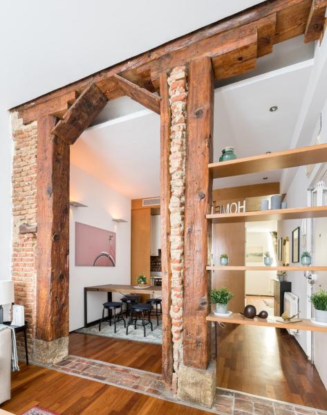 una sala de estar abierta con vigas de madera y un comedor.  en El Olivar de la Paz, en Madrid