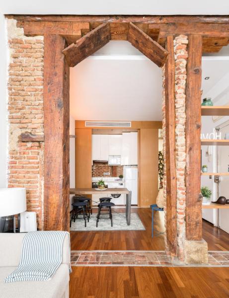 una sala de estar con una pared de ladrillo y una mesa en El Olivar de la Paz, en Madrid