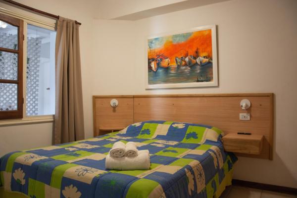 Un dormitorio con una cama con una toalla. en Alma Departamentos de Mar en Ostende