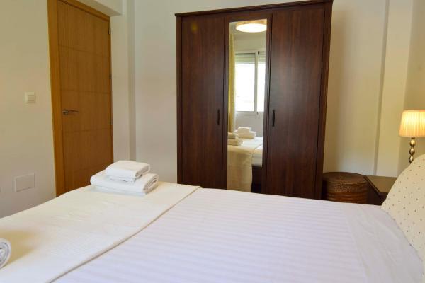 1 dormitorio con cama blanca y espejo en Letmalaga Sorolla, en Málaga