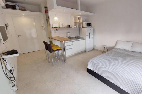 1 dormitorio con 1 cama y cocina con mesa en Colombres 585 by depptö en Buenos Aires