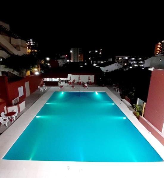 una piscina azul en la parte superior de un edificio por la noche en Intersur Villa Gesell en Villa Gesell