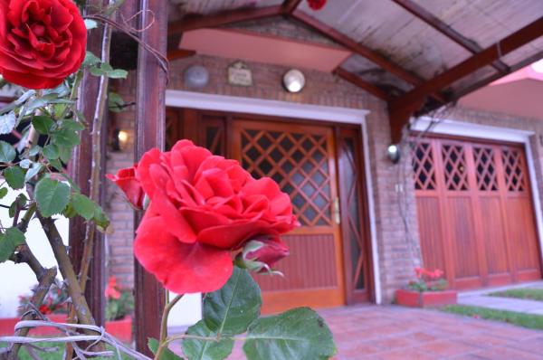una rosa roja frente a una casa en Departamentos Familiares Roses Roges en Villa Gesell