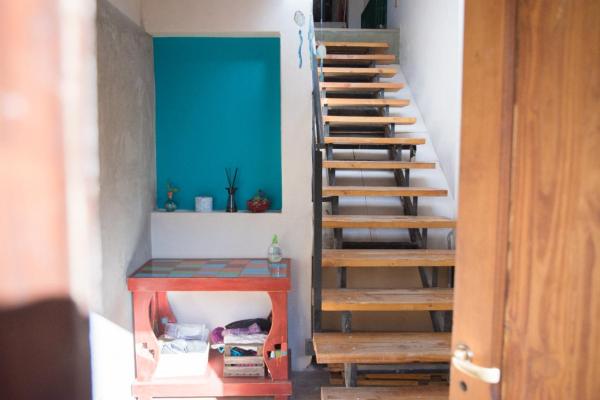 una escalera en una habitación con una mesa roja y una pared azul en Habitación privada en Nuestra Casa del Pueblo en Esquel