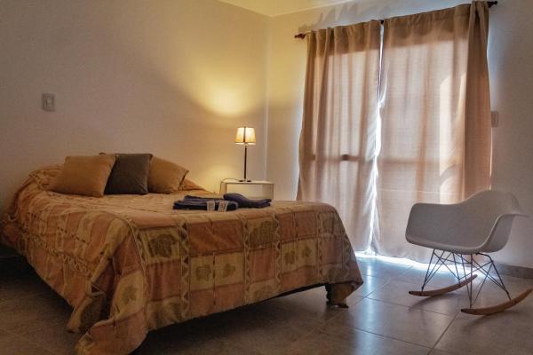 1 dormitorio con 1 cama, 1 silla y 1 lámpara en CIELO de Jujuy ll en San Salvador de Jujuy