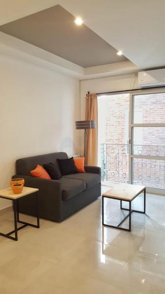 sala de estar con sofá negro y 2 mesas en AltoAndino - Excelente Ubicación - p/4 c/cochera en Salta