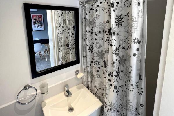 baño con lavabo y cortina de ducha en Departamento 3 ambientes - Amarras Pinamar en Pinamar