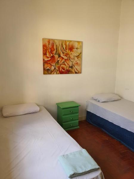 Habitación con 2 camas y una pintura en la pared. en Aero Hostel perto do Aeroporto Congonhas CGH e do Consulado Americano, en São Paulo