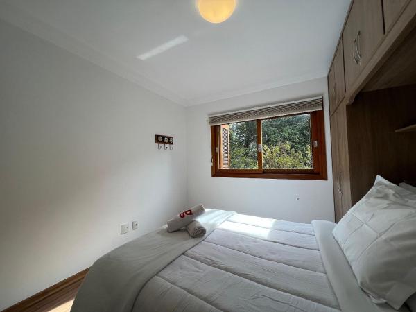 un dormitorio con una cama con un animal de peluche en Vista do Quilombo 204B - Apartamento no Centro de Gramado, en Gramado