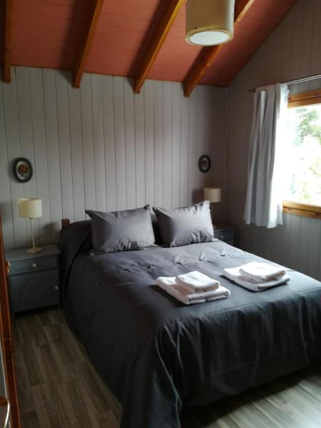 1 dormitorio con 1 cama con 2 toallas en CASA ANDINA en San Martín de los Andes