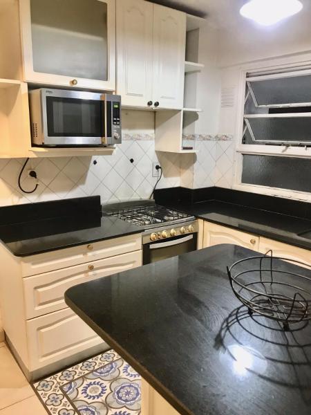 cocina con armarios blancos y encimera negra en APARTAMENTO SANTA FE EXCLUSIVO, UNICO, EXCELENTE UBICACION en Buenos Aires