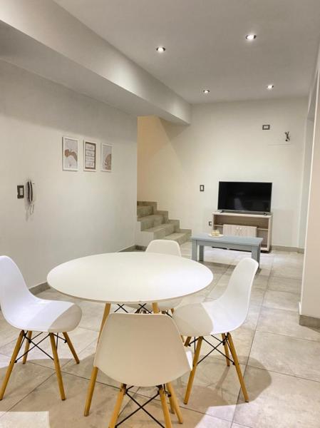 una mesa blanca y sillas en una habitación en Departamento nuevo y moderno frente al Parque San Martín en Mendoza
