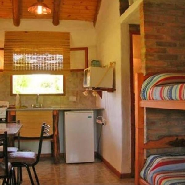 cocina pequeña con refrigerador y litera en Cabanas Parparim, en Mina Clavero