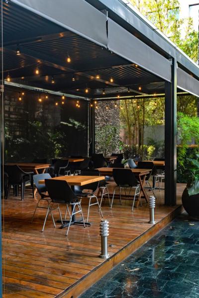 un patio con mesas y sillas y una piscina en Apart-Hotel TerraEsperanza, en Guatemala