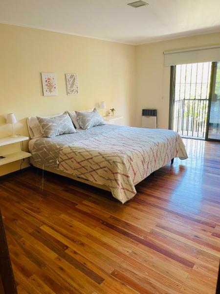 1 dormitorio con 1 cama y suelo de madera en Exclusivo Departamento a metros de Parque San Martín! en Mendoza