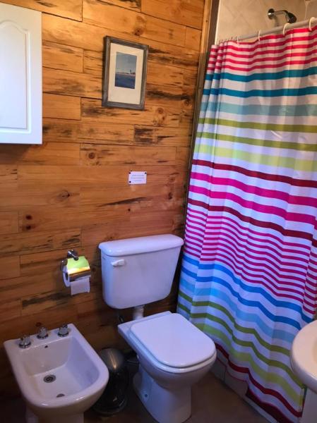 y baño con aseo y cortina de ducha.  en Cabañas Villa Centauro en San Carlos de Bariloche