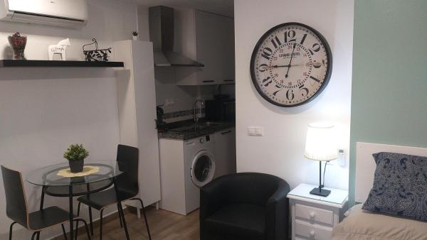 sala de estar con mesa y reloj en la pared en Victoria Habitación Boutique de Torremolinos, en Torremolinos
