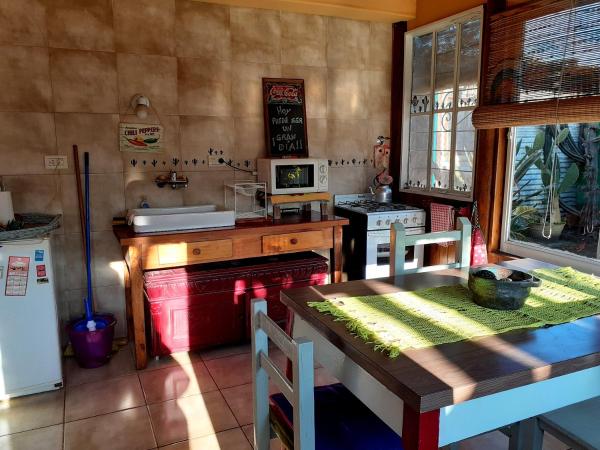 cocina con mesa, fogones y microondas en Sauce Grande en Tandil