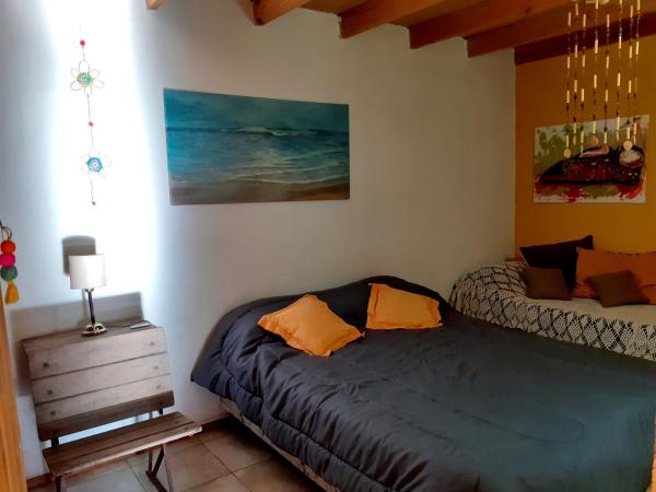 1 dormitorio con 1 cama y una pintura en la pared en Sauce Grande en Tandil