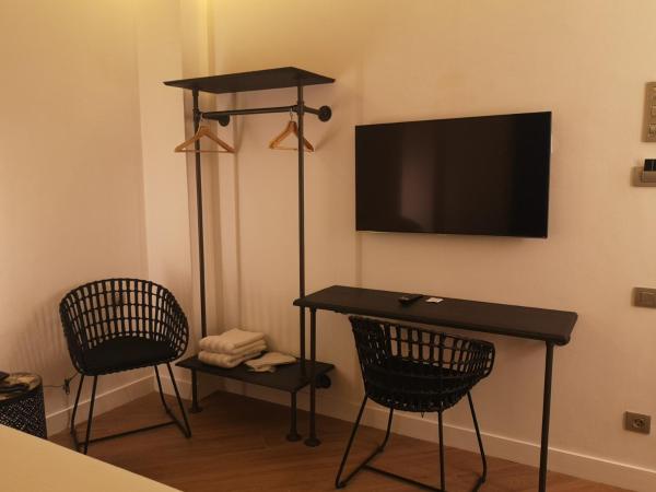 Habitación con mesa, 2 sillas y TV.  en H La Paloma Adults Only, en Barcelona