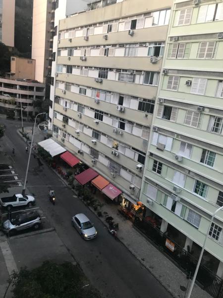 un edificio de apartamentos con coches estacionados frente a él en Incrivel quarto sala Ipanema em frente ao metro - Jangadeiros duas quadras da praia, en Río de Janeiro