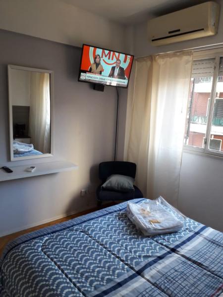 1 dormitorio con cama, silla y espejo en Departamento zona congreso con balcón a la calle en Buenos Aires