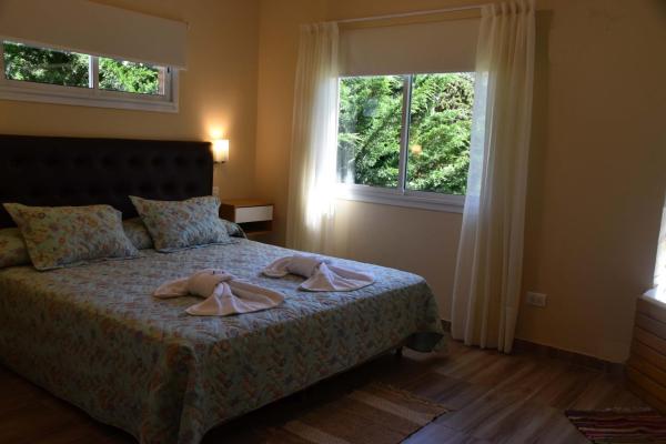 1 dormitorio con 1 cama con 2 toallas en Cabanas Luces el Bosque, en Mar de las Pampas
