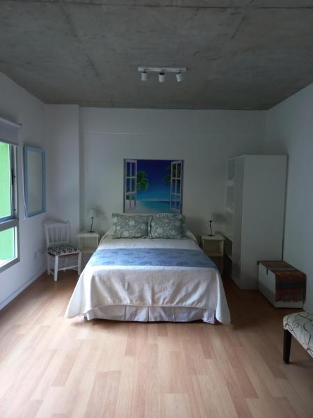 1 dormitorio con 1 cama grande y suelo de madera en Grace210 en Buenos Aires