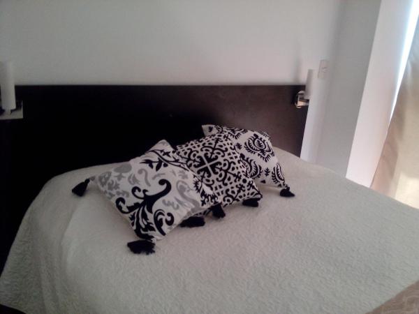Una cama con almohadas blancas y negras. en Aparts Zapata, Palermo Hollywood en Buenos Aires