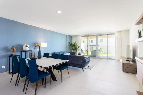 comedor con mesa y sillas azules en Luxury Apartment private pool 3 Bedrooms OR23 by AORASTAY, en Málaga