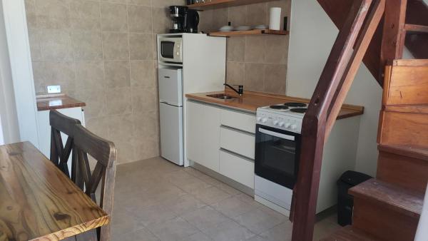 una pequeña cocina con encimera y nevera.  en Sintra Aparts, en Mar de las Pampas