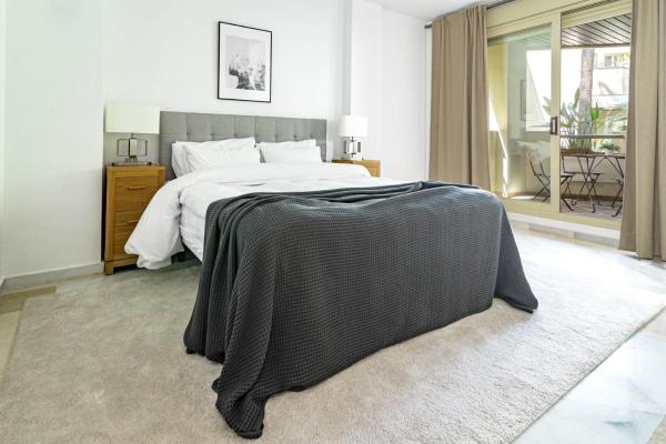 Un dormitorio con cama con manta negra.  en FA- Luxury 2 bedroom apt Font Aloha, en Marbella
