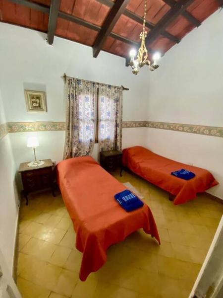 1 dormitorio con 2 camas y lámpara de araña en Colonial Grande - Terraza encantadora pleno centro en Salta