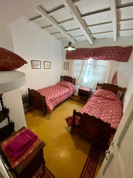1 dormitorio con 2 camas y 2 sillas en Colonial Grande - Terraza encantadora pleno centro en Salta