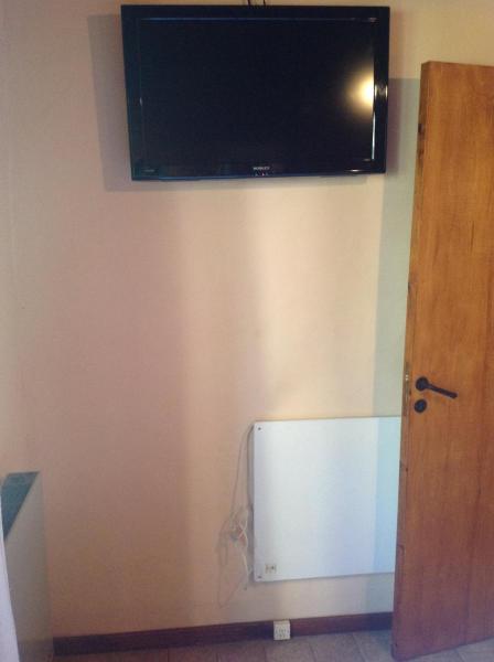 TV de pantalla plana en la pared de una habitación en Abvai, en Mar de las Pampas