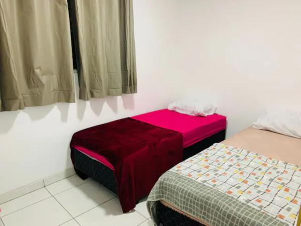 Habitación pequeña con 2 camas y manta roja. en 2 dormitórios SP - Bairro Tremembé/ Tucuruvi, en São Paulo