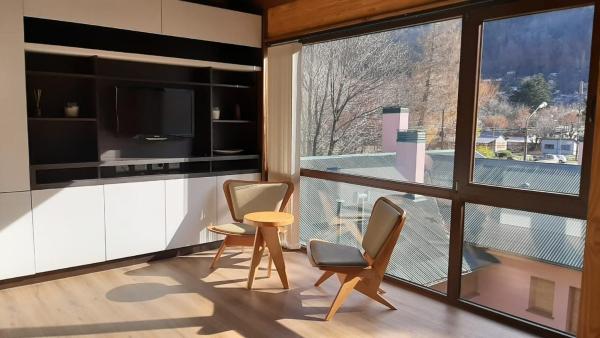 sala de estar con 2 sillas y ventana grande en Monoambiente de diseño único, muy cálido y bien ubicado. 18V2 en San Martín de los Andes