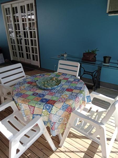 a dining room table with chairs and a quilt on it at Vivenda Fagundes in Florianópolis