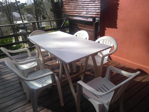una mesa blanca y 4 sillas en una terraza en casa lila 2cuadras del mar en Balneario Mar Azul