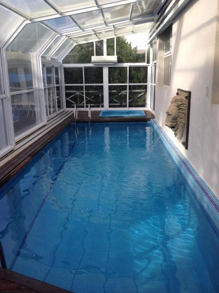 una piscina en una casa con una ventana grande en Olas Apart High Comfort en Villa Gesell