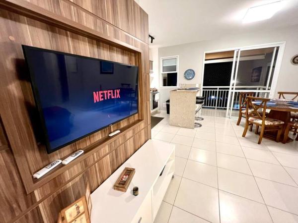 a living room with a flat screen tv on a wall at Apto Completo condomínio tipo Resort Praia dos Ingleses in Florianópolis