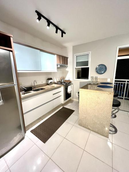 a kitchen with white tile flooring and stainless steel appliances at Apto Completo condomínio tipo Resort Praia dos Ingleses in Florianópolis