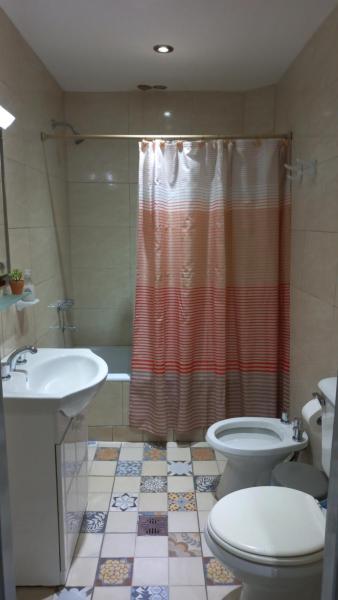 y baño con aseo, lavabo y ducha. en Departamento amplio - Mendoza Centro en Mendoza