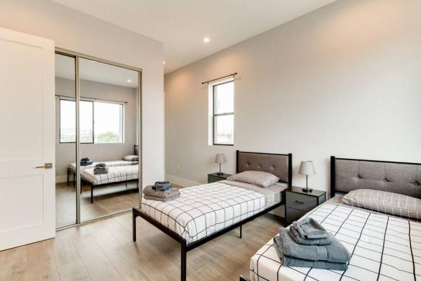 1 dormitorio con 2 camas y espejo en 2 New Luxury Modern 3 story homes, en Los Ángeles
