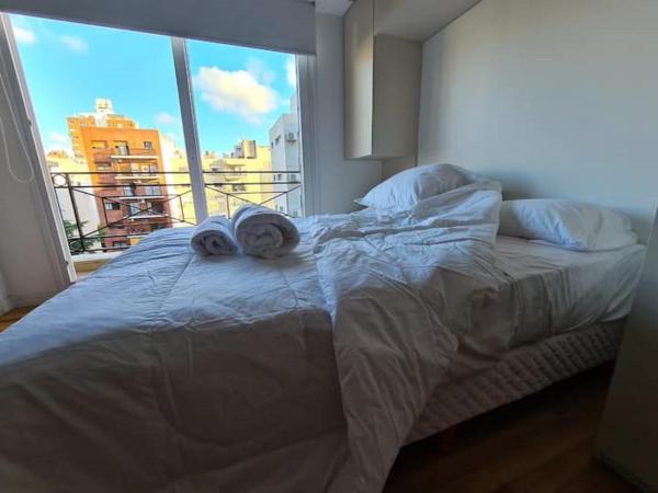 1 cama en un dormitorio con ventana grande en Deluxe Apartment in excellent location en Buenos Aires