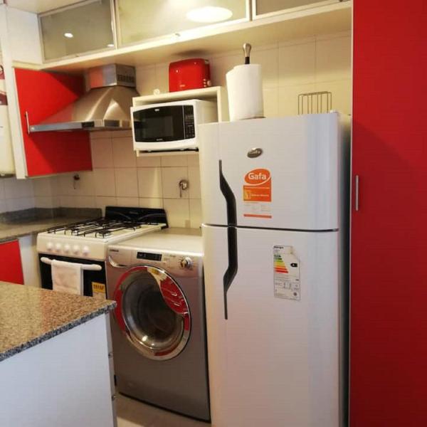 cocina con refrigerador y lavadora en Cozy apartment in the heart of Cañitas en Buenos Aires