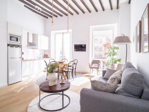 sala de estar con sofá y mesa en Sanders Lavender - Delightful Two-Bedroom Apartment Downtown, en Málaga